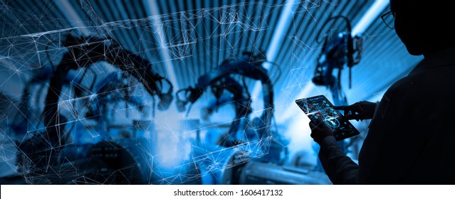Factory Female Industrial Engineer working with automation robot arms machine in intelligent factory industrial on real time monitoring system software.Digital future manufacture. - Shutterstock ID 1606417132