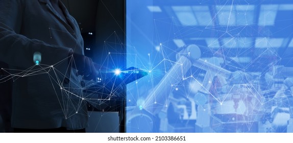 Factory Female Industrial Engineer working with automation robot arms machine in intelligent factory industrial on real time monitoring system software.Digital future manufacture.