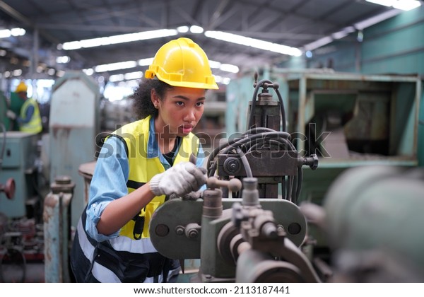 Factory Female Industrial Engineer Works in\
metal working factory, Inside the Heavy Industry. Portrait of\
working female industry technical worker or engineer woman working\
in an industrial.