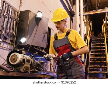 Factory female worker sharpening tools - Powered by Shutterstock