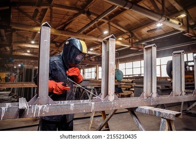 Factory industrial weld worker in workplace with spark. Professional welder erecting metal steel.