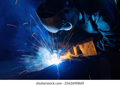 Factory industrial welder worker in workplace with spark, neon light. Professional welder fix industry truck.