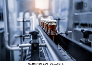 Factory Interior Of Beverage, Production Line Of Manufacturing And Packaging Juice Products, Close Up, Glass Bottles With Screw Caps Standing On A Conveyor Belt