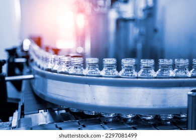 Factory interior of beverage, Production line of manufacturing and Herbal drink products, packaging juice, Glass bottles with screw caps standing on a conveyor belt. Healthy Drink Industry. - Powered by Shutterstock