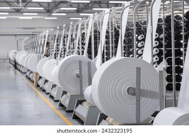 Factory. Interior of a factory workshop for the production of polypropylene bags. Racks with rolls and coils. Without people.