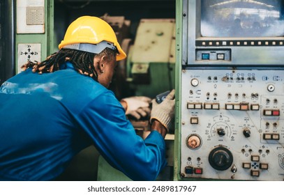 Factory maintenance worker uses flashlight to inspect and perform maintenance on industrial machine. The image highlights the importance of safety and attention to detail in an industrial environment - Powered by Shutterstock