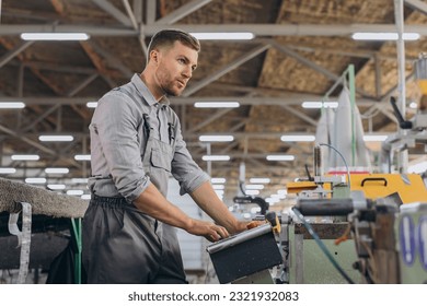 Factory male bearded worker is programming a CNC milling machine with copy space.