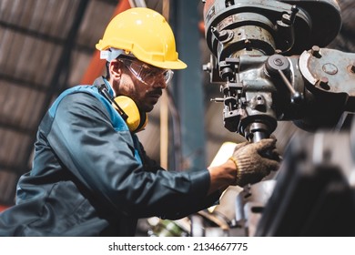 Factory male worker. Engineer man worker in plant production drilling at machine in smart factory wearing yellow hard hat safety first at mechanic factory. - Powered by Shutterstock