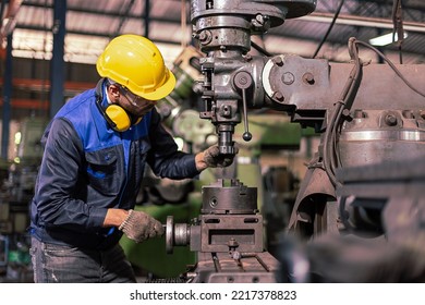 Factory male worker. Engineer man worker in plant production drilling at machine in smart factory wearing yellow hard hat safety first at mechanic factory. - Powered by Shutterstock