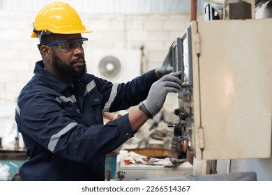 Factory male worker at work in the industry factory, work with CNC machine. Factory engineer male worker maintaining machine in the industrial factory - Powered by Shutterstock