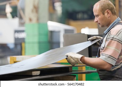 Factory Man Worker Holding Metal Sheet in Workshop during Manufacturing Process 