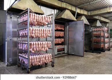 Factory for manufacturing sausages with unrecognizable worker in the background