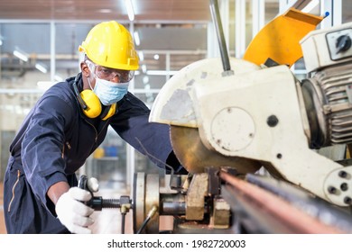 A factory mechanic is using a chainsaw to cut copper pipes. An expert technician is inspecting industrial machinery in a steel manufactory. - Powered by Shutterstock