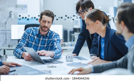 Factory Meeting Room: Multi-Ethnic and Diverse Team of Engineers, Managers, Investors Talking Sitting at Conference Table, Analyzing Blueprints, Mechanism Component. High-Tech Manufactory Optimization - Powered by Shutterstock