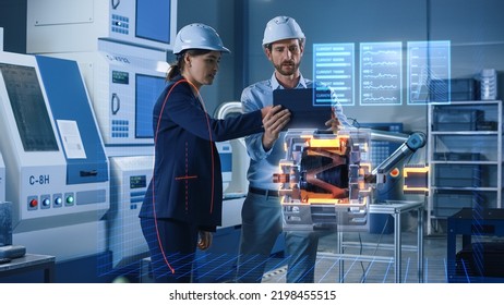 Factory Office Facility: Chief Engineer Holds Tablet Computer, Shows Augmented Reality Model Of Electric Generator To A Female Project Manager. High Tech Industry 4.0 Research And Development Concept.