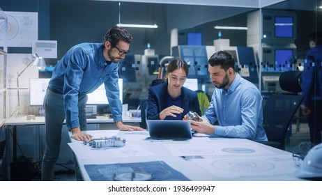 Factory Office Meeting Room: Team of Engineers Gather Around Conference Table, They Discuss Project Blueprints, Inspect Mechanism, Find Solutions, Use Laptop. Industrial Technology Factory - Shutterstock ID 1936499947