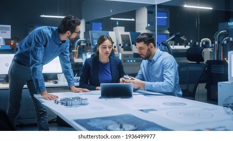 Factory Office Meeting Room: Team of Engineers Gather Around Conference Table, They Discuss Project Blueprints, Inspect Mechanism, Find Solutions, Use Laptop. Industrial Technology Factory - Shutterstock ID 1936499977