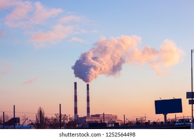 From the factory pipe smoke runs into the blue sky, the eology in the city in Ukraine at sunset. - Shutterstock ID 1252564498