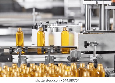 Factory Process Of Production New Cosmetics. Glass Bottles Standing On Conveyor Line Going To Be Twisted. Automated Process On Big Factory. Production Of New Shampoo On Coveyor Belt.Innovation Concept