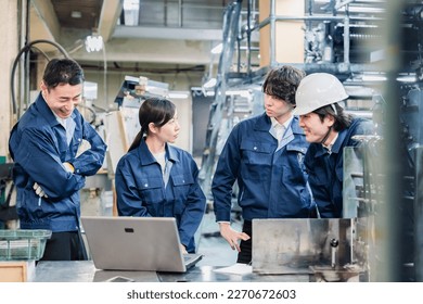 Factory staff discussing over a computer - Powered by Shutterstock