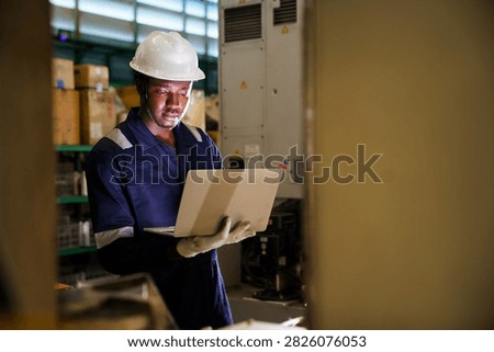 Factory supervisor conducting routine walkthrough inspection along machinery production line inside industrial plant. Technician checking equipment operational status and maintenance.