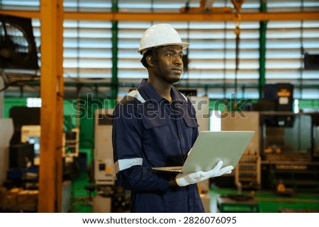 Factory supervisor conducting routine walkthrough inspection along machinery production line inside industrial plant. Technician checking equipment operational status and maintenance.