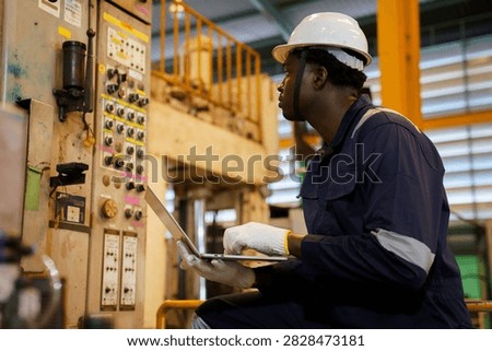 Factory supervisor conducting routine walkthrough inspection along machinery production line inside industrial plant. Technician checking equipment operational status and maintenance.