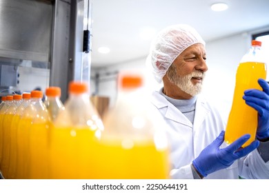 Factory supervisor controlling production of bottled orange juice for the market. - Powered by Shutterstock