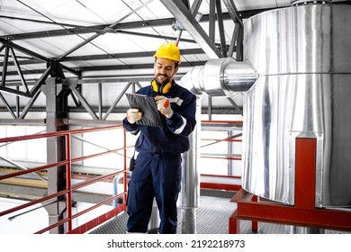 Factory Supervisor Standing In Heating Plant Boiler Room Checking Temperature.