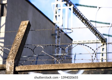 Factory Wall With Barbed Wire And Roof Access Ladder. 
Set Of Protection Systems For Sensitive Sites