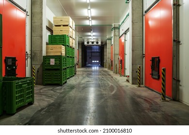 A Factory Warehouse With No People In It. Empty Storage Space With Lots Of Pallets Neatly Stacked In The Factory. The Dark Atmosphere Of A Closed Warehouse Without People. Distribution And Logistics