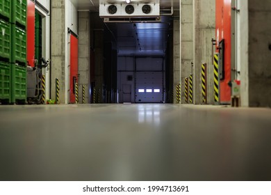 A Factory Warehouse Where There Are No People. Empty Storage Space And Hallway With Lots Of Pallets. The Dark Atmosphere Of A Closed Warehouse Without People. Distribution And Cargo