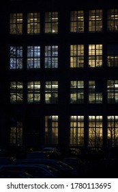 The factory windows have lights at night.