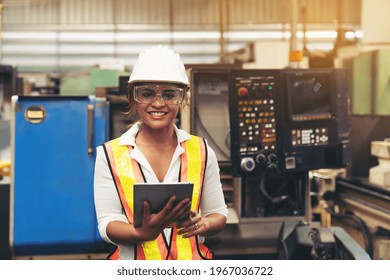 Factory woman worker at work in the industry factory, work with digital tablet with happy and smile. Female worker maintaining machine in the industrial plant - Powered by Shutterstock