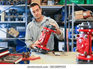 Factory worker assembles shutoff valves using various tools