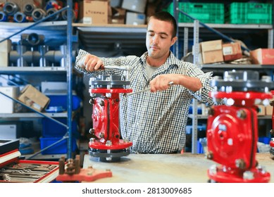 Factory worker assembles shutoff valves using various tools