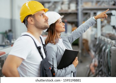 Factory worker and engineer doing inspection. Factory worker and businesswoman at production line.