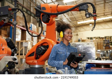 factory worker or engineer operating remote switch controller to control robot machine in the factory - Shutterstock ID 2191749053