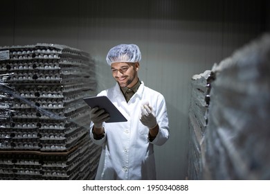 Factory Worker With Hairnet And Hygienic Gloves Holding Tablet Computer And Checking Inventory In Food Cold Storage.