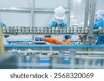 Factory worker in hygienic gear inspecting cans on a production line, showcasing food processing, quality control, and adherence to safety and cleanliness standards.