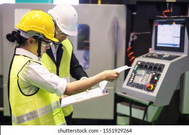 Factory worker inspector or manager discuss inspection report on paper for internal audit at high technology machine. Quality assurance (QA) for manufacturing industry.