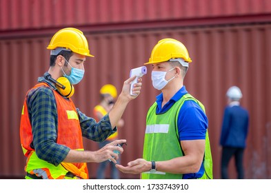 Factory worker man checking fever by digital thermometer for scan and protect from Coronavirus (COVID-19) at cargo containers - Healthcare Concept - Powered by Shutterstock