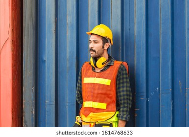 Factory worker man in hard hat standing relaxing at container box