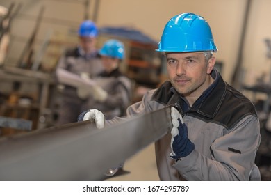 Factory worker with a metal bar
