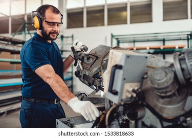 Factory worker operating band saw cutting machine for steel bars in the industrial factory - Powered by Shutterstock