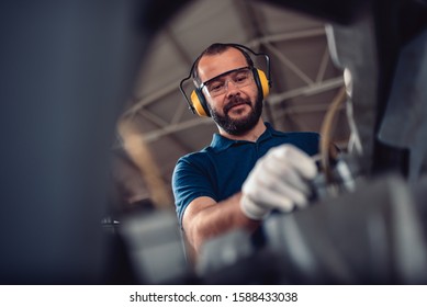 Factory worker operating band saw cutting machine for steel bars in the industrial factory - Powered by Shutterstock