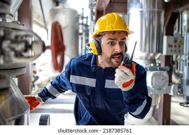 Factory worker in panic using radio communication to alert about fire and explosion in refinery production plant. Problems at work. - Shutterstock ID 2187385761