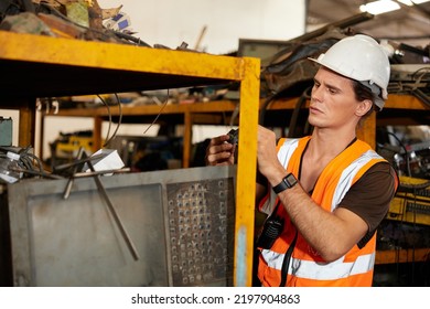 Factory Worker Picking Scrap Metal On Shelf In Old Warehouse