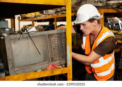 Factory Worker Picking Scrap Metal On Shelf In Old Warehouse