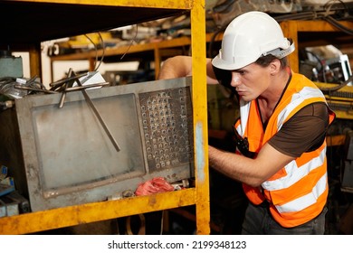 Factory Worker Picking Scrap Metal On Shelf In Old Warehouse